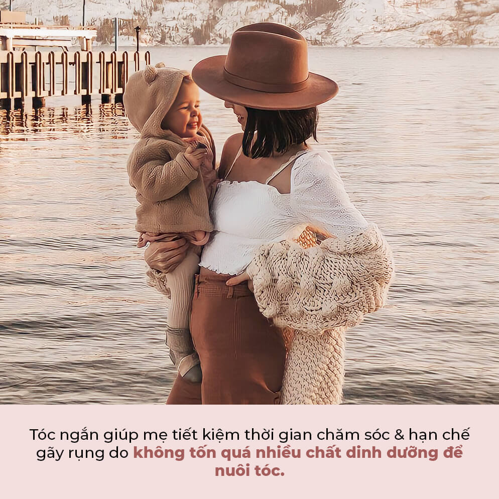 Mẹ và bé tận hưởng khoảnh khắc bên bờ hồ, chia sẻ niềm vui. Tóc ngắn giúp mẹ tiết kiệm thời gian chăm sóc và hạn chế gãy rụng do không tốn quá nhiều chất dinh dưỡng để nuôi tóc. Khắc phục rụng tóc sau sinh với mẹo đơn giản.
