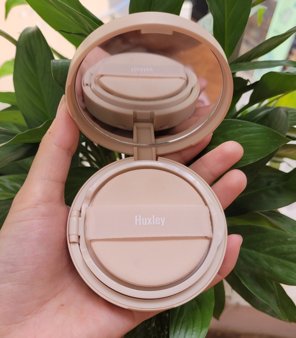 Phấn nước Huxley trong bài viết đánh giá mỹ phẩm, mô tả trải nghiệm sử dụng cho da hỗn hợp thiên dầu, với khả năng kiềm dầu và dưỡng ẩm hiệu quả, giúp trang điểm nhanh chóng và dễ dàng hơn.