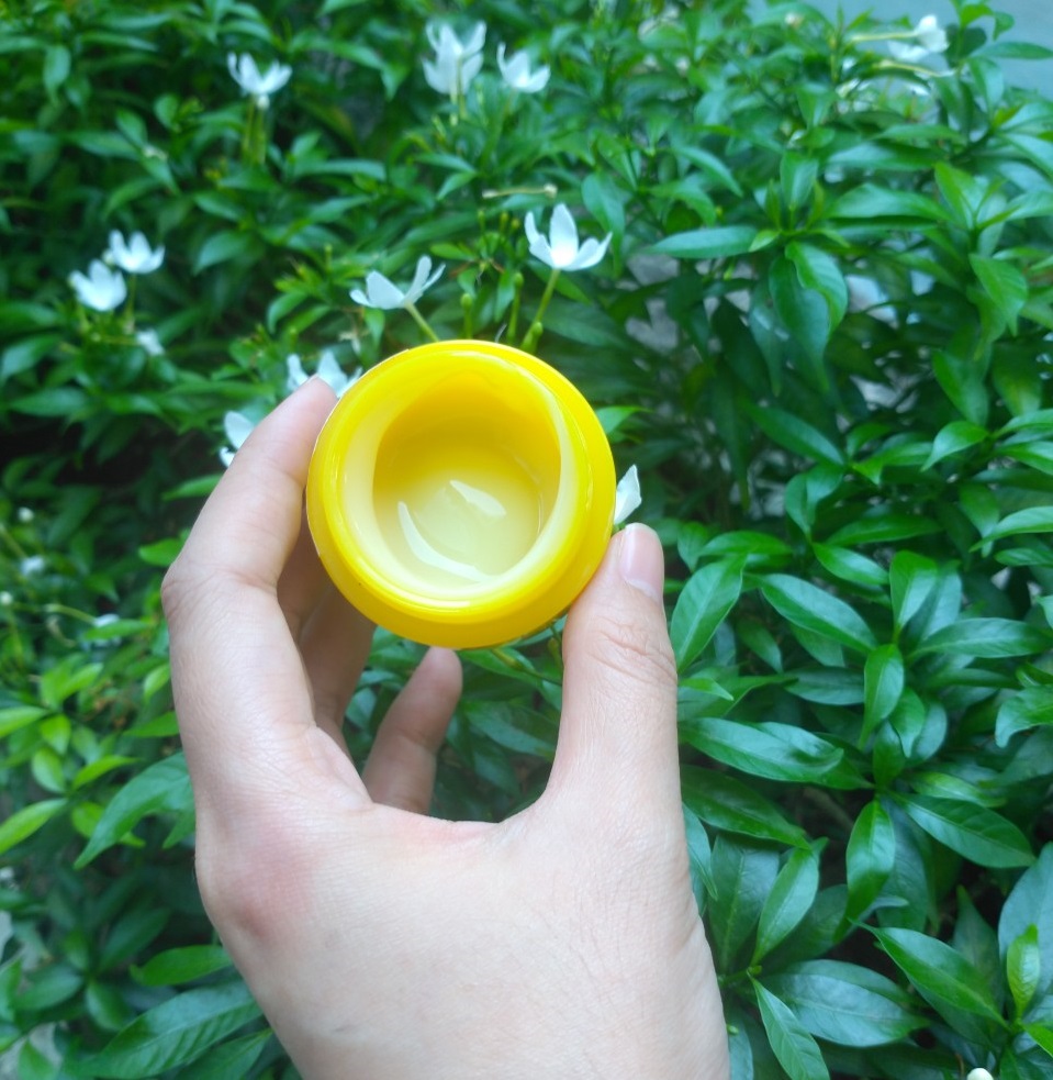 Mặt nạ ngủ Some By Mi Yuja Niacin 30 Days Miracle Brightening Sleeping Mask trong tay, với thiết kế màu vàng nổi bật. Bài viết review mặt nạ ngủ dưỡng trắng, đánh giá mặt nạ ngủ Some By Mi có tốt không cho làn da sáng, cùng sự tiện lợi không cần bảo quản lạnh như serum.