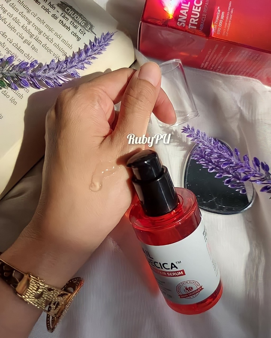 Bài viết review tinh chất Some By Mi Snail Truecica Miracle Repair Serum, sản phẩm trị sẹo mụn hiệu quả với giá hợp lý. Hình ảnh serum ốc sên trên tay, kèm theo hoa để tạo cảm giác dễ chịu.