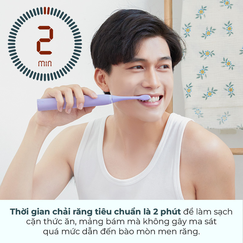 Một người đàn ông đang chải răng bằng bàn chải điện màu tím, nhìn hướng về phía trước. Thời gian chải răng tiêu chuẩn là 2 phút để làm sạch cặn thức ăn, màng bám mà không gây ma sát quá mức dẫn đến bào mòn men răng. Đây là lưu ý quan trọng trong việc bảo vệ sức khỏe răng miệng và tránh các sai lầm khi chải răng.