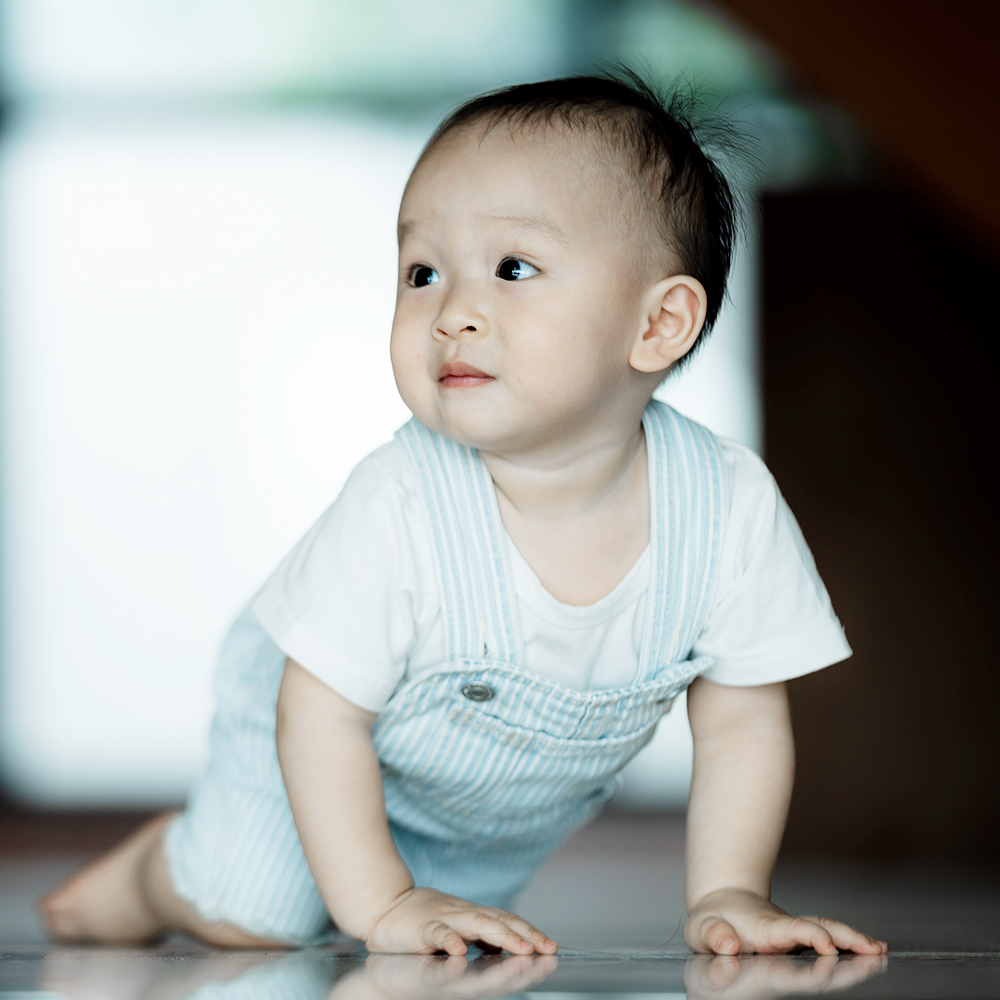 Bé đang tập bò trong nhà, biểu hiện sự khởi đầu giai đoạn dạy trẻ tập đi. Cột mốc quan trọng này đánh dấu sự tiến bộ của mẹ và bé trong hành trình phát triển. Bài viết hướng dẫn mẹ những điều nên và không nên khi trẻ tập đi.