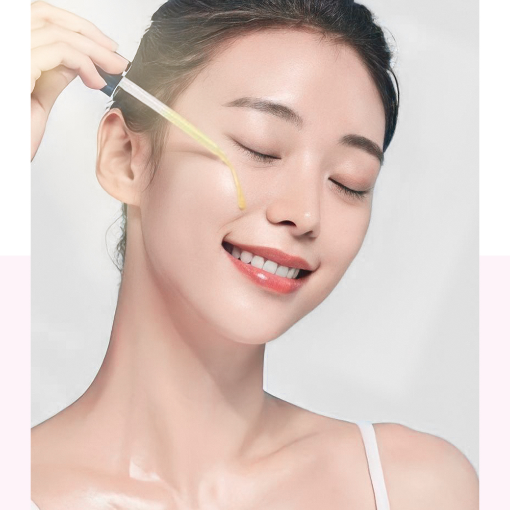Cô gái trẻ sử dụng tinh chất chăm sóc da trên khuôn mặt, thể hiện làn da mềm mại và sáng bóng, minh họa cho các bước skincare tối giản. Bài viết chia sẻ lưu ý từ bác sĩ da liễu Mỹ, giúp làm đẹp hiệu quả với vitamin C, Hyaluronic Acid và kem chống nắng.