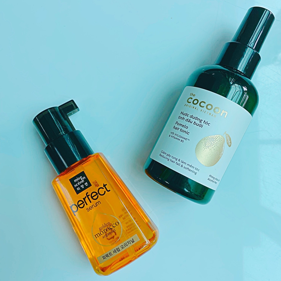 Hai sản phẩm dưỡng tóc, gồm serum Perfect của Mise En Scène và nước dưỡng tóc Cocoon, được giới thiệu trong bài viết khám phá cách chăm sóc tóc đúng cách và phục hồi tóc xơ yếu với mức giá dưới 150K.