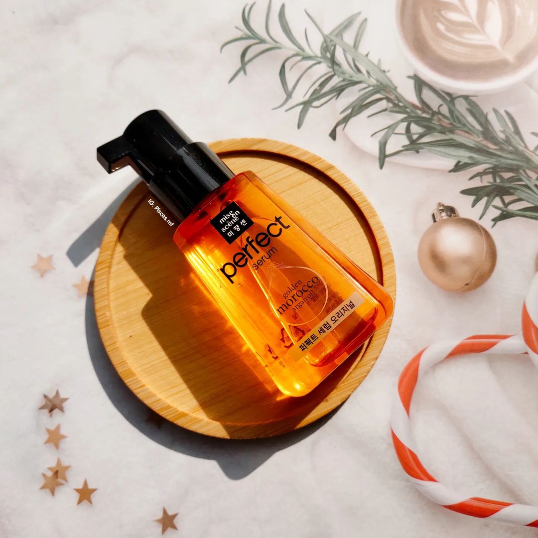 Sản phẩm tóc Mise En Scène Perfect Serum Golden Morocco trên bàn gỗ, dành cho việc chăm sóc tóc đúng cách. Bài viết chia sẻ về cách cải thiện tình trạng tóc xơ yếu nhờ vào sản phẩm dưỡng tóc hiệu quả dưới 150K, phù hợp cho những ai thường xuyên tạo kiểu tóc.
