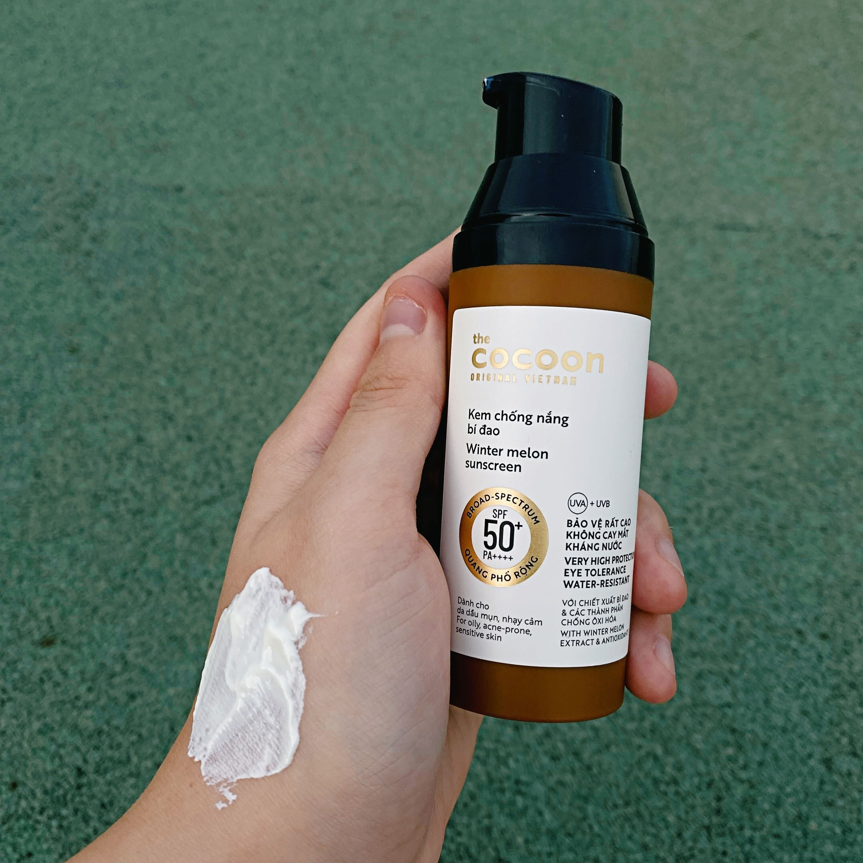 Kem chống nắng Bí Đao Quang Phổ Rộng Bảo Vệ Rất Cao SPF 50 + PA ++++ của thương hiệu Cocoon, được cầm trên tay với lượng kem đã thoa lên mu bàn tay. Sản phẩm đang gây tranh cãi trên MXH và được review bởi Lixibox.