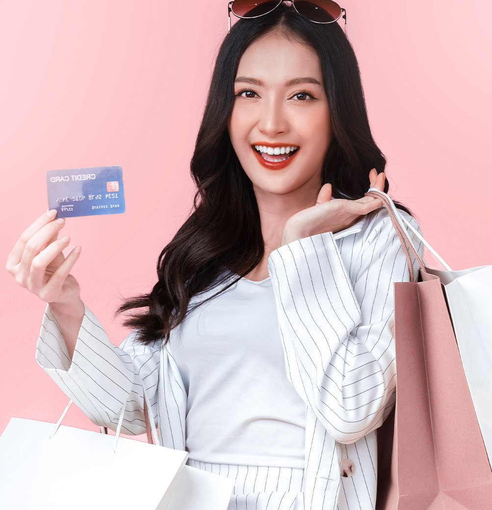 Một phụ nữ trẻ cầm thẻ tín dụng và túi mua sắm, đang vui vẻ với cơ hội săn quà GWP 3 triệu tại Lixibox. Bài viết chia sẻ 5 lý do chính đáng để không bỏ lỡ deal đặc biệt này!