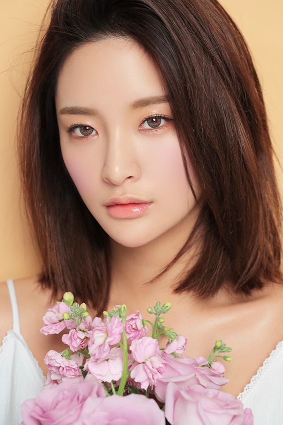 Phong cách makeup mùa hè rực rỡ với các xu hướng hot như Hàn Quốc, tông màu đào. Cô gái trẻ trung với làn da sáng, đôi mắt quyến rũ, cùng bó hoa tươi xinh tạo nên vẻ đẹp hoàn hảo cho mùa hè.