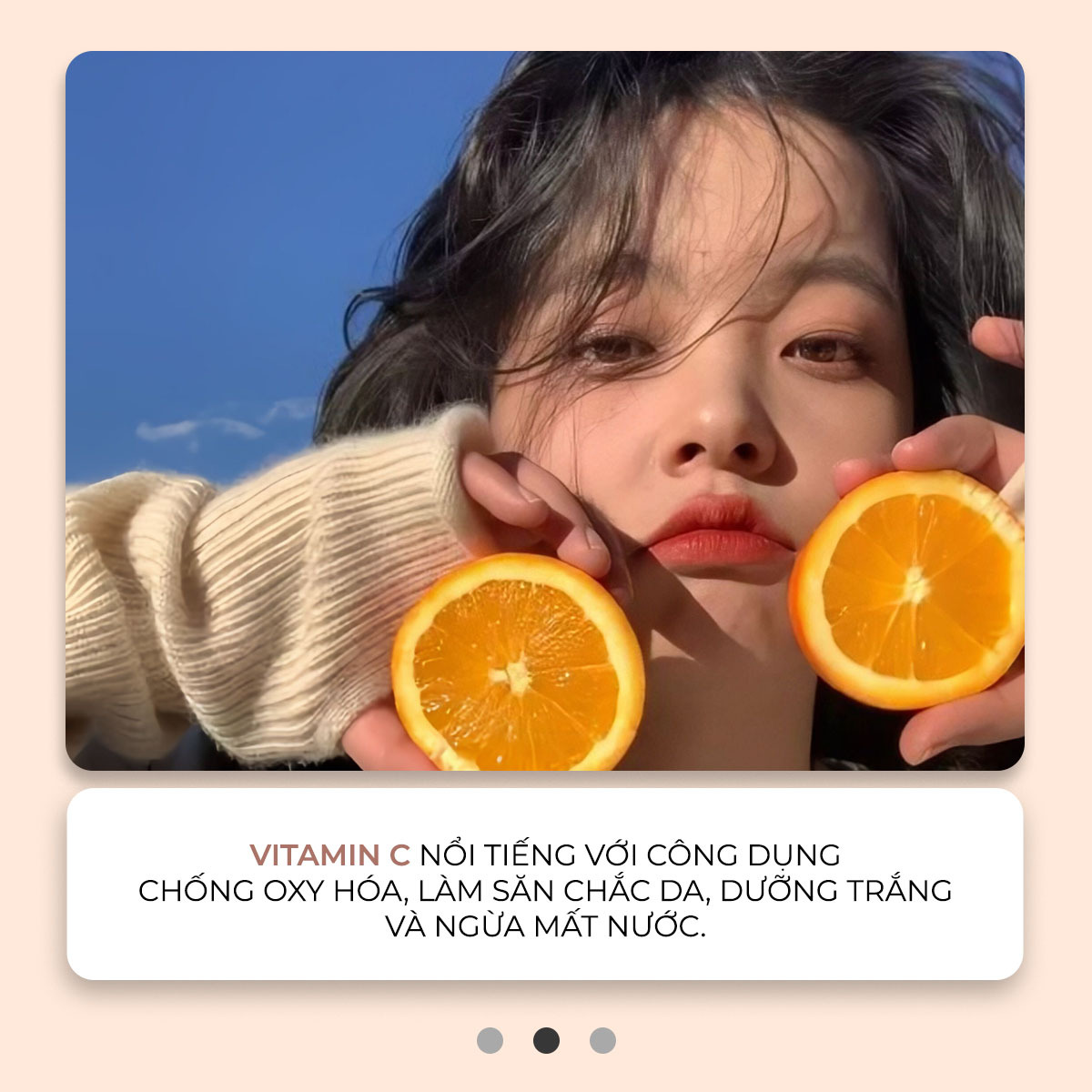 Chân dung một cô gái trẻ cầm hai quả cam trên tay, thể hiện tác dụng của Vitamin C trong việc dưỡng da, chống oxy hóa và cấp ẩm. Khám phá các loại Vitamin tốt nhất cho da với Lixibox.