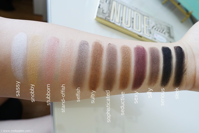 Bảng màu phấn mắt từ bảng phấn drugstore, gồm các sắc thái: sassy, snobby, stubborn, stand-offish, selfish, sultry, sophisticated, seductive, sexy, silly, serious, sleek, trình bày trên tay với tổng cộng 12 màu sắc đa dạng.