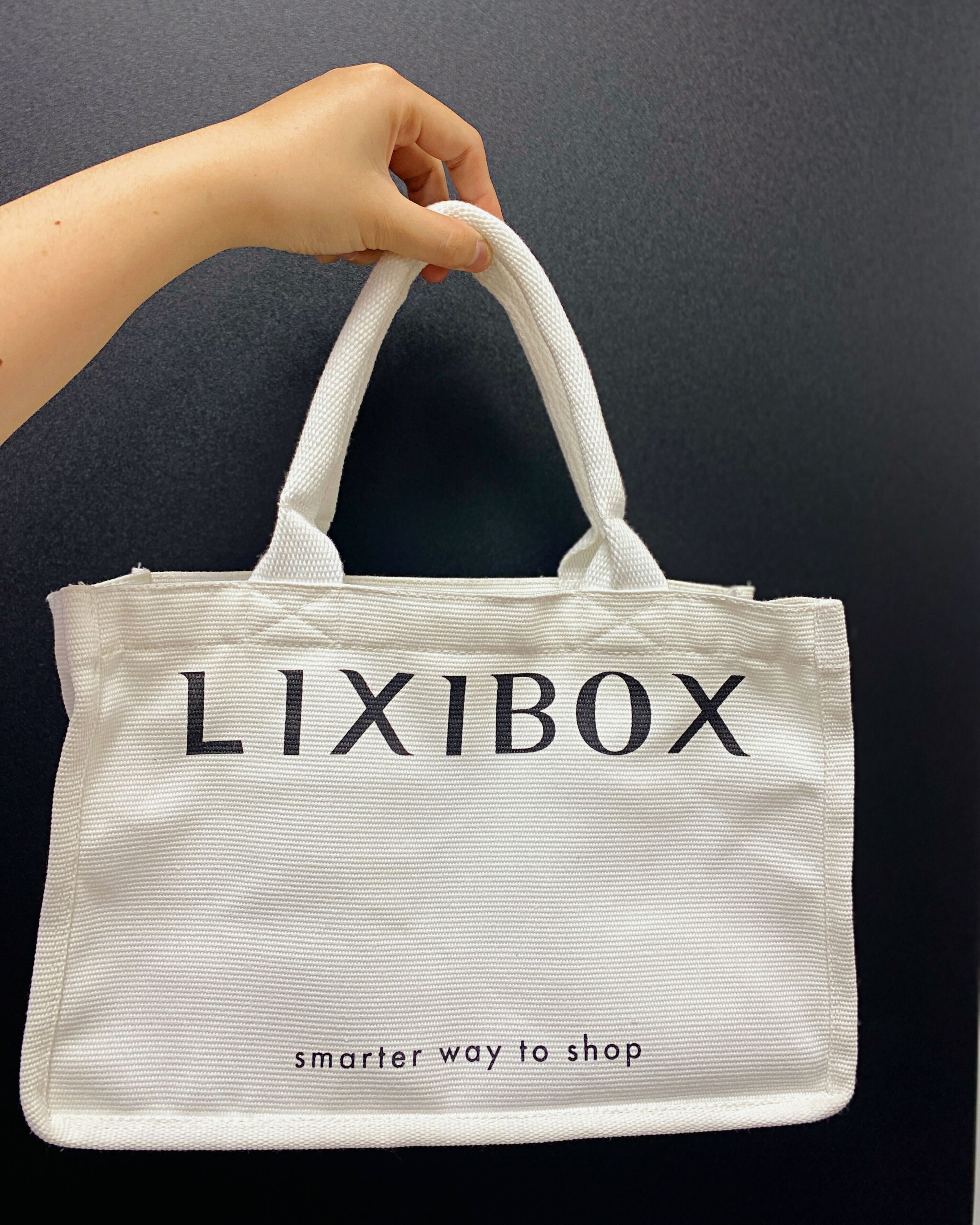 Túi Lixibox màu trắng với chữ in đen, chứa đựng bí kíp nhận quà GWP trị giá 3 triệu đồng. Khám phá cách sở hữu bàn chải điện và máy rửa mặt Halio mà không tốn tiền qua bài review của gái xinh về GWP2010.