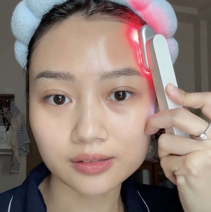 Gương mặt của một người phụ nữ trẻ đang sử dụng liệu pháp ánh sáng đỏ (Red Light Therapy) với máy ánh sáng đỏ Halio. Cô ấy thể hiện sự hào hứng khi trải nghiệm công nghệ làm đẹp này, một xu hướng đang thu hút sự chú ý của nhiều tín đồ làm đẹp ở Việt Nam.