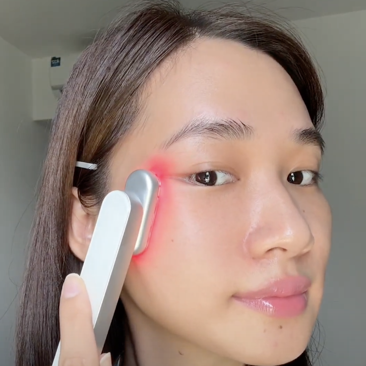 Một người phụ nữ đang sử dụng thiết bị máy ánh sáng đỏ Halio trên mặt, thể hiện liệu pháp ánh sáng đỏ (Red Light Therapy - RLT) đang trở thành xu hướng chăm sóc sắc đẹp tại Việt Nam, được nhiều tín đồ như Châu Bùi, Dino Vũ yêu thích.