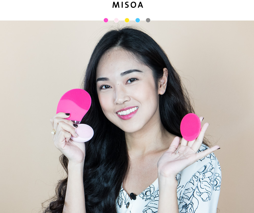 Tina cầm máy rửa mặt Halio với nụ cười rạng rỡ, thể hiện sự hài lòng về sản phẩm skincare này, được đánh giá là "rất sạch", "da mềm và căng", "giảm hẳn mụn" trong bài viết về máy rửa mặt Halio trên Lixibox.