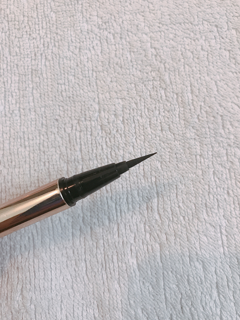 Bút kẻ mắt LUSTRE Make-Up trên nền khăn trắng. Sản phẩm này nằm trong set mỹ phẩm chính hãng Lustre, kèm theo nhiều sản phẩm trang điểm khác, mang đến trải nghiệm làm đẹp hoàn hảo.