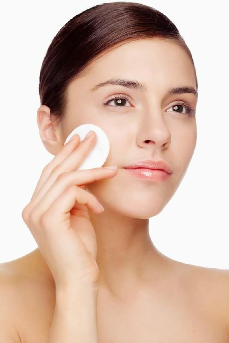 Chân dung một cô gái trẻ thực hiện các bước dưỡng da cơ bản với bông tẩy trang, mang lại cảm giác nhẹ nhàng và tự nhiên. Bài viết hướng dẫn cho những người mới bắt đầu chăm sóc da về quy trình dưỡng da hiệu quả.