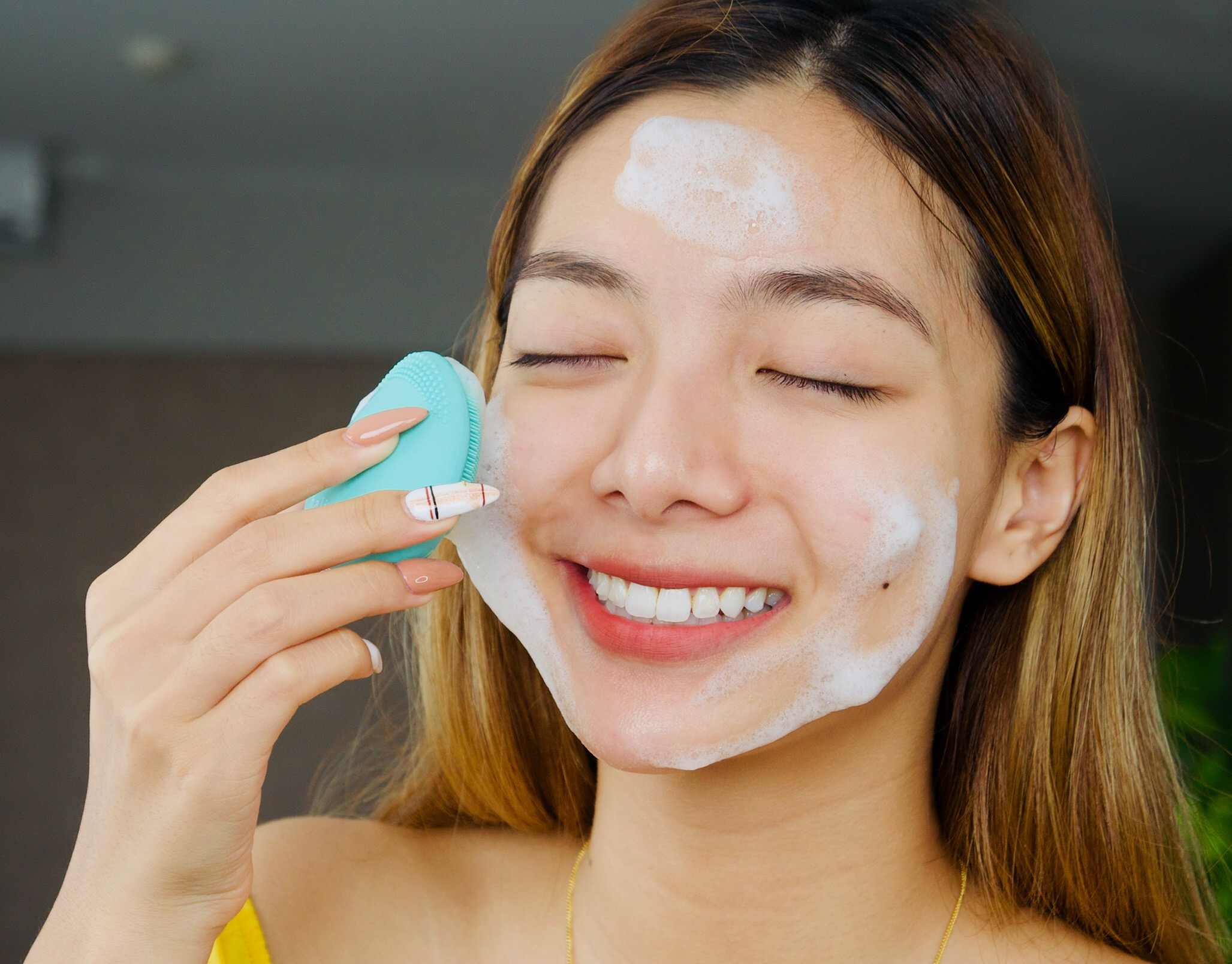 Người phụ nữ chăm sóc da mặt với dụng cụ rửa mặt Halio Sensitive, thể hiện quy trình dưỡng da cơ bản. Bài viết nhấn mạnh tầm quan trọng của một skin care routine chuẩn để đạt hiệu quả chăm sóc da tối ưu.