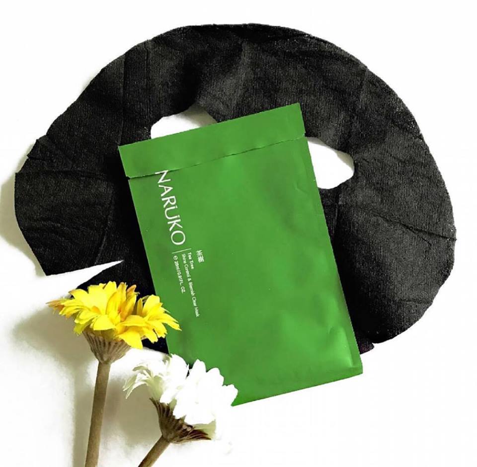 Mặt nạ cho da dầu với sản phẩm NARUKO trên bàn cùng hoa, thể hiện các giải pháp skin care routine giúp hạn chế đổ dầu, chiến đấu với mụn đầu đen và chăm sóc da cơ bản cho nàng da dầu.