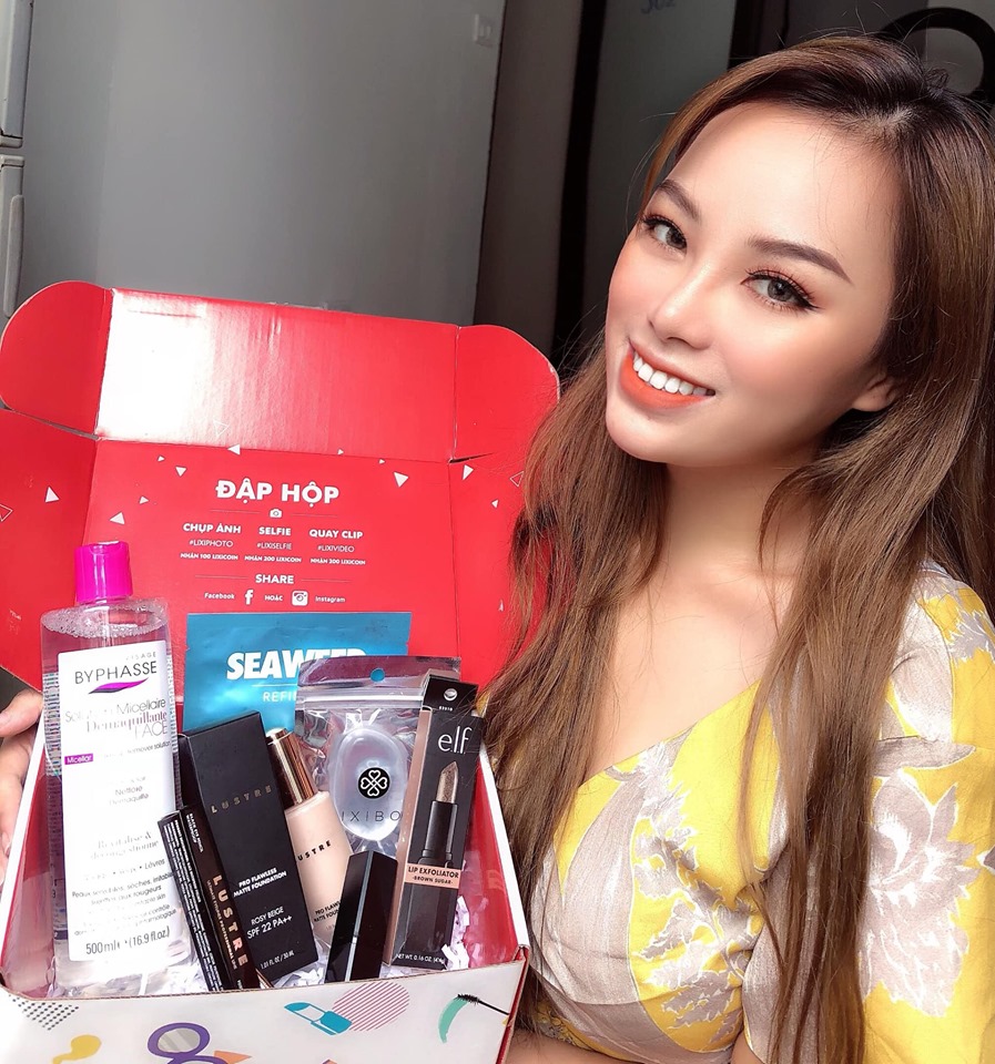 Cô gái tươi cười khoe hộp quà mỹ phẩm xinh xắn nhân dịp 20/10, bên trong chứa sản phẩm của Byphasse, Luvia và ELF, tạo nên khoảnh khắc đập hộp vui vẻ cùng Lixibox.