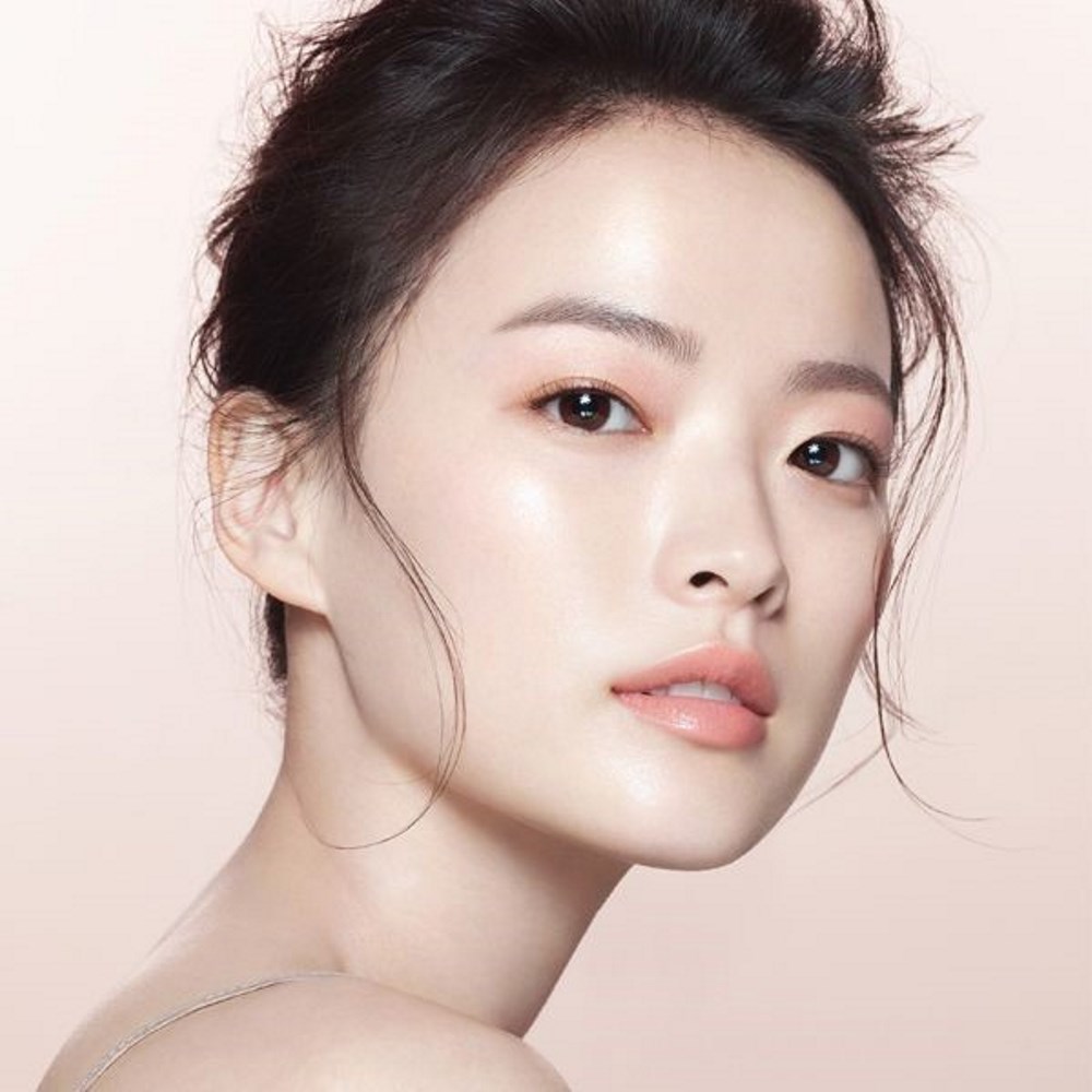 Chân dung người phụ nữ với lớp trang điểm tự nhiên hoàn hảo, làn da bóng khỏe và sắc môi tự nhiên, thể hiện kỹ thuật trang điểm đơn giản nhưng hiệu quả. Bài viết khám phá các loại kem nền cần thiết để có lớp trang điểm tự nhiên lung linh.
