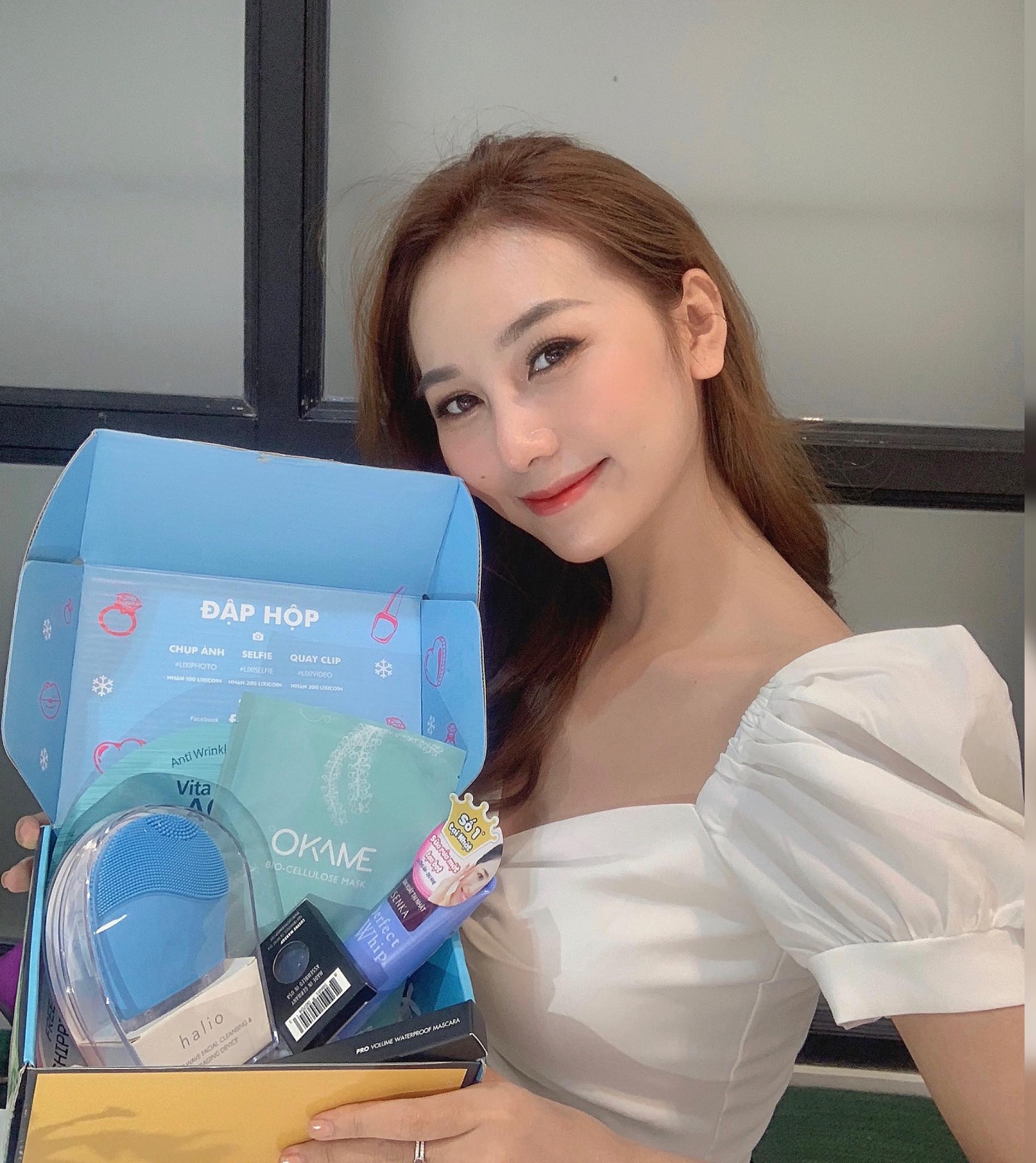 Người phụ nữ trẻ cầm hộp quà với nhiều sản phẩm chăm sóc sắc đẹp, đại diện cho top 5 quà tặng được mong đợi nhất vào ngày Valentine tại Lixibox. Gói quà tặng kèm GWP hấp dẫn cho người yêu thích làm đẹp.