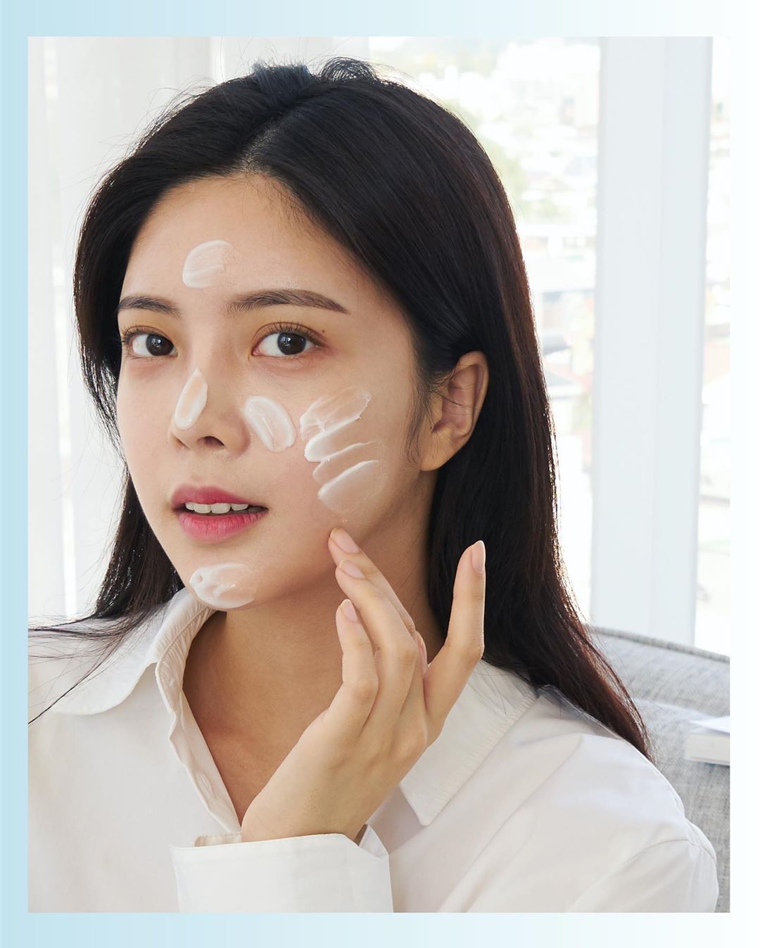 Một cô gái trẻ chăm sóc da mặt với sản phẩm dưỡng trắng, thể hiện quy trình dưỡng da cơ bản để đạt được làn da sáng mịn, mờ thâm. Bài viết 'Sáng mịn, mờ thâm với quy trình dưỡng da đơn giản' chia sẻ bí quyết chăm sóc da hiệu quả.