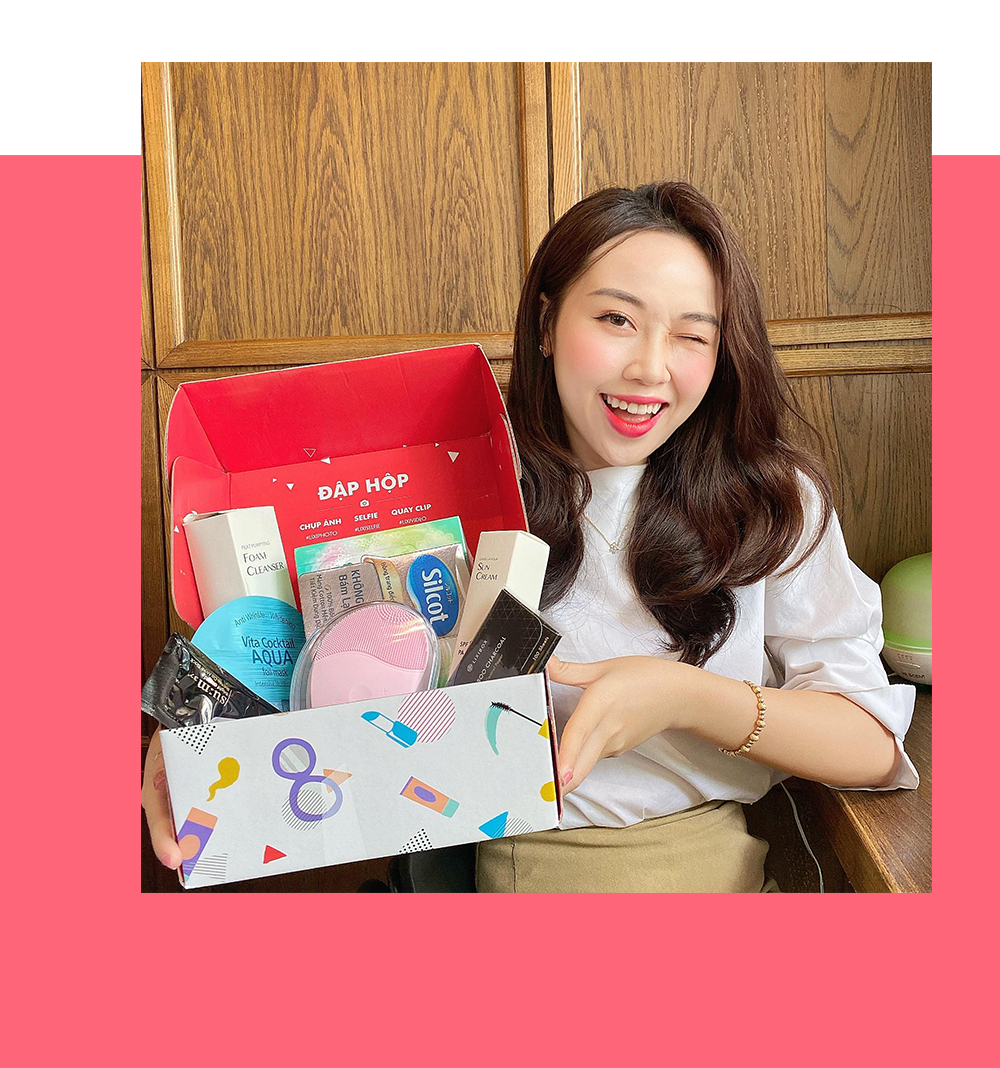 Cô gái vui vẻ cầm hộp quà tặng GWP từ Lixibox, bên trong chứa nhiều sản phẩm làm đẹp và chăm sóc bản thân. Bài viết giới thiệu 5 ý tưởng quà sinh nhật độc đáo cho bạn bè và đồng nghiệp, đặc biệt trong chương trình "Gift with Purchase" (GWP) tại Lixibox.
