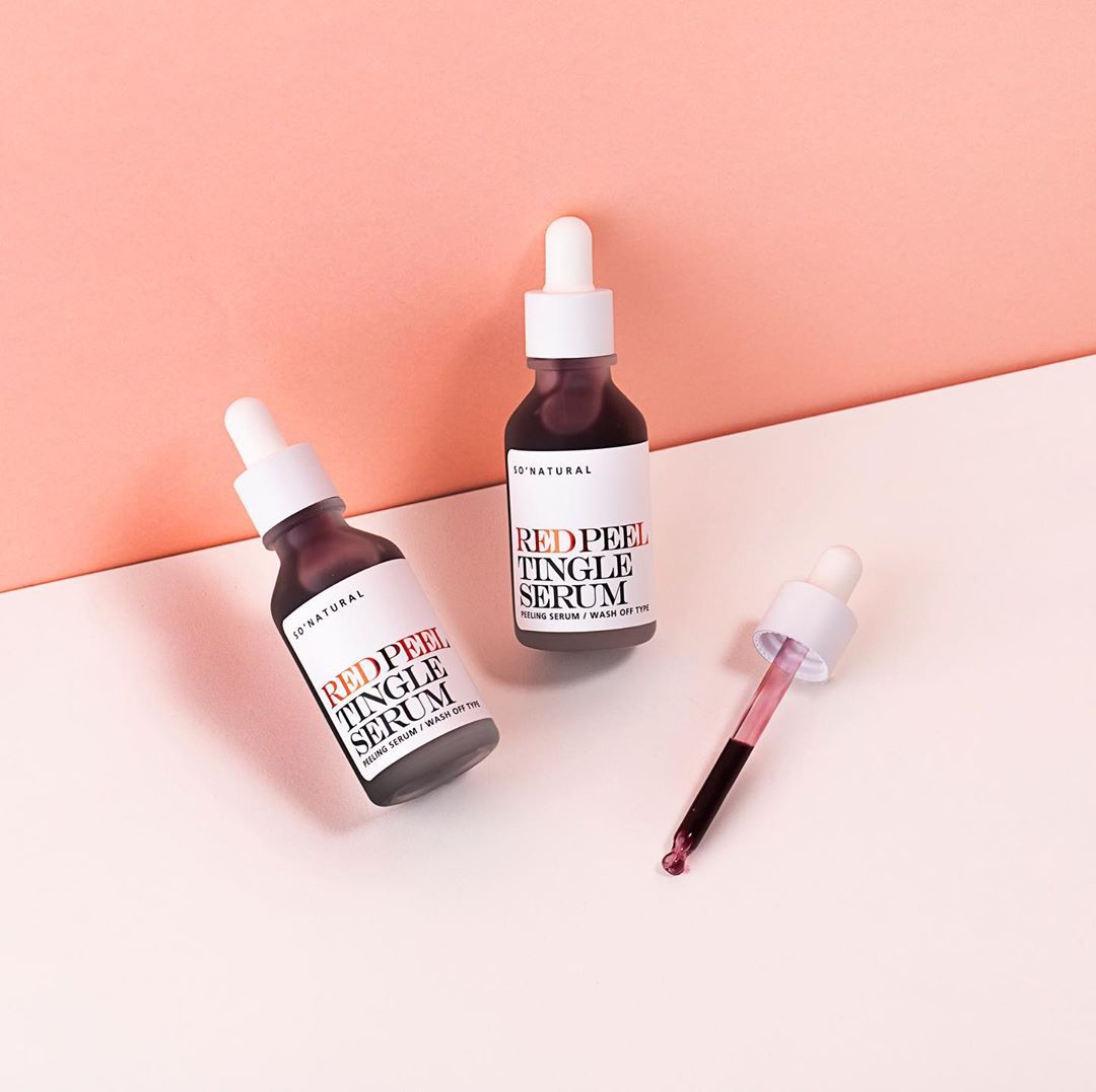 Hai chai serum RED PEEL TINGLE trên nền hồng nhạt. Bài viết chia sẻ bí quyết chăm sóc da cơ bản giúp giảm thâm mụn sau 2 tuần với quy trình dưỡng da đơn giản.