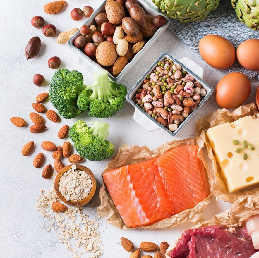 Mâm thực phẩm dinh dưỡng phong phú gồm cá hồi, trứng, hạt hoặc các loại đậu, broccol, và các loại hạt khô, giúp mẹ bầu duy trì chế độ dinh dưỡng hợp lý để không tăng cân quá đà trong thai kỳ.