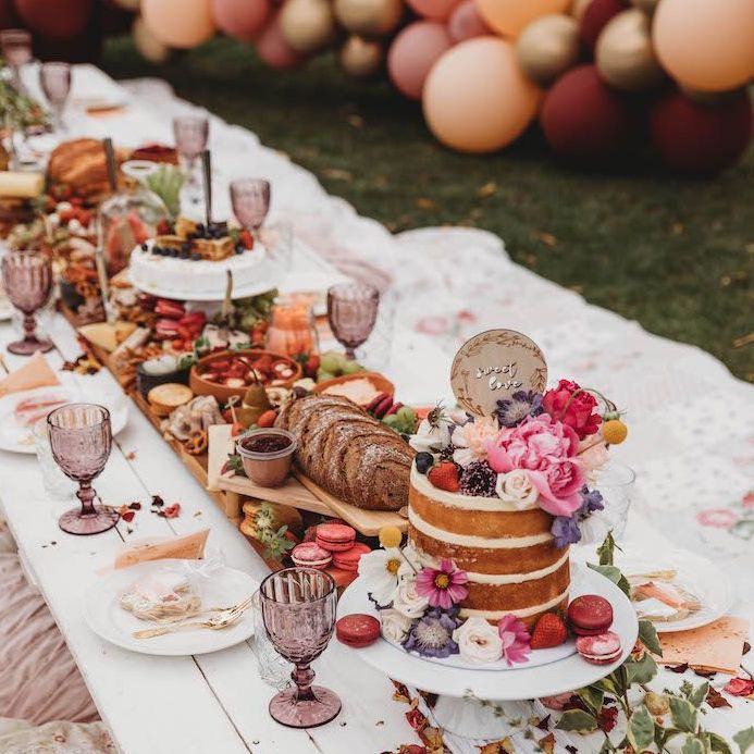 Mâm tiệc Baby Shower được trang trí đẹp mắt với bánh kem hoa tươi, trái cây tươi ngon và đồ ăn hấp dẫn. Không khí vui tươi với bàn tiệc rộng rãi, phù hợp cho bữa tiệc chào đón em bé sắp ra đời.