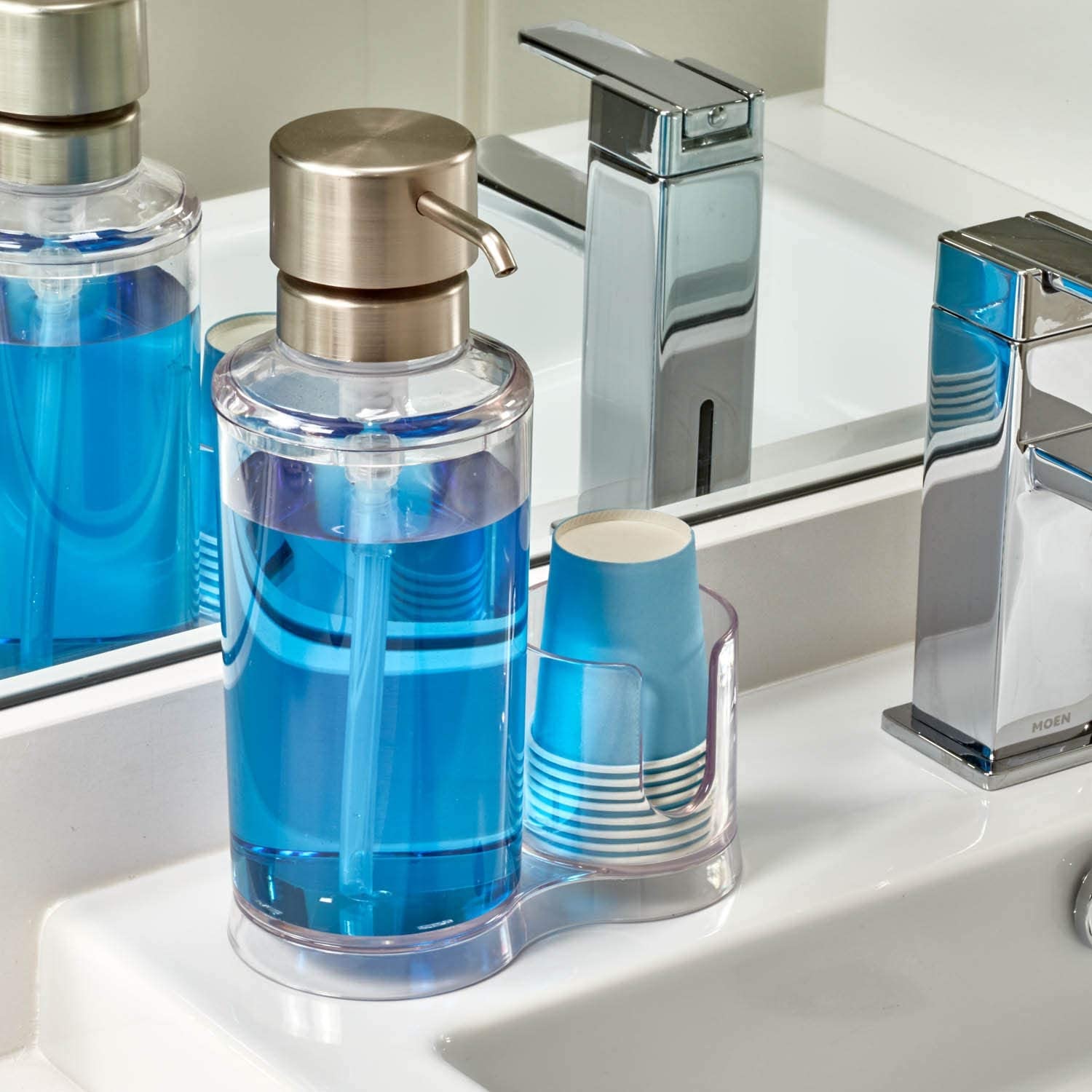 Sản phẩm chăm sóc răng miệng bao gồm nước súc miệng với màu xanh, kèm theo cốc nhựa, phù hợp cho quá trình chăm sóc răng niềng. Điều này hỗ trợ làm sạch răng hiệu quả giữa các lần niềng và giúp đánh bay mùi hôi miệng.