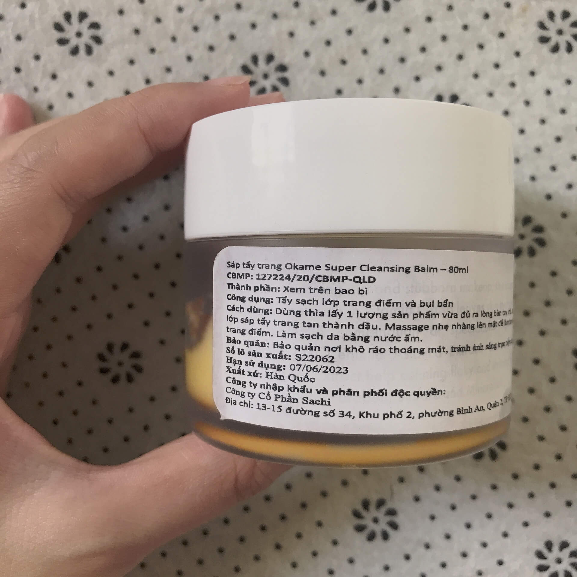 Sáp tẩy trang Okame Super Cleansing Balm 80ml với công dụng tẩy sạch lớp trang điểm và bụi bẩn, là sản phẩm lý tưởng cho những ai dễ bị kích ứng. Ghi chú với ngày sản xuất và thông tin liên quan.