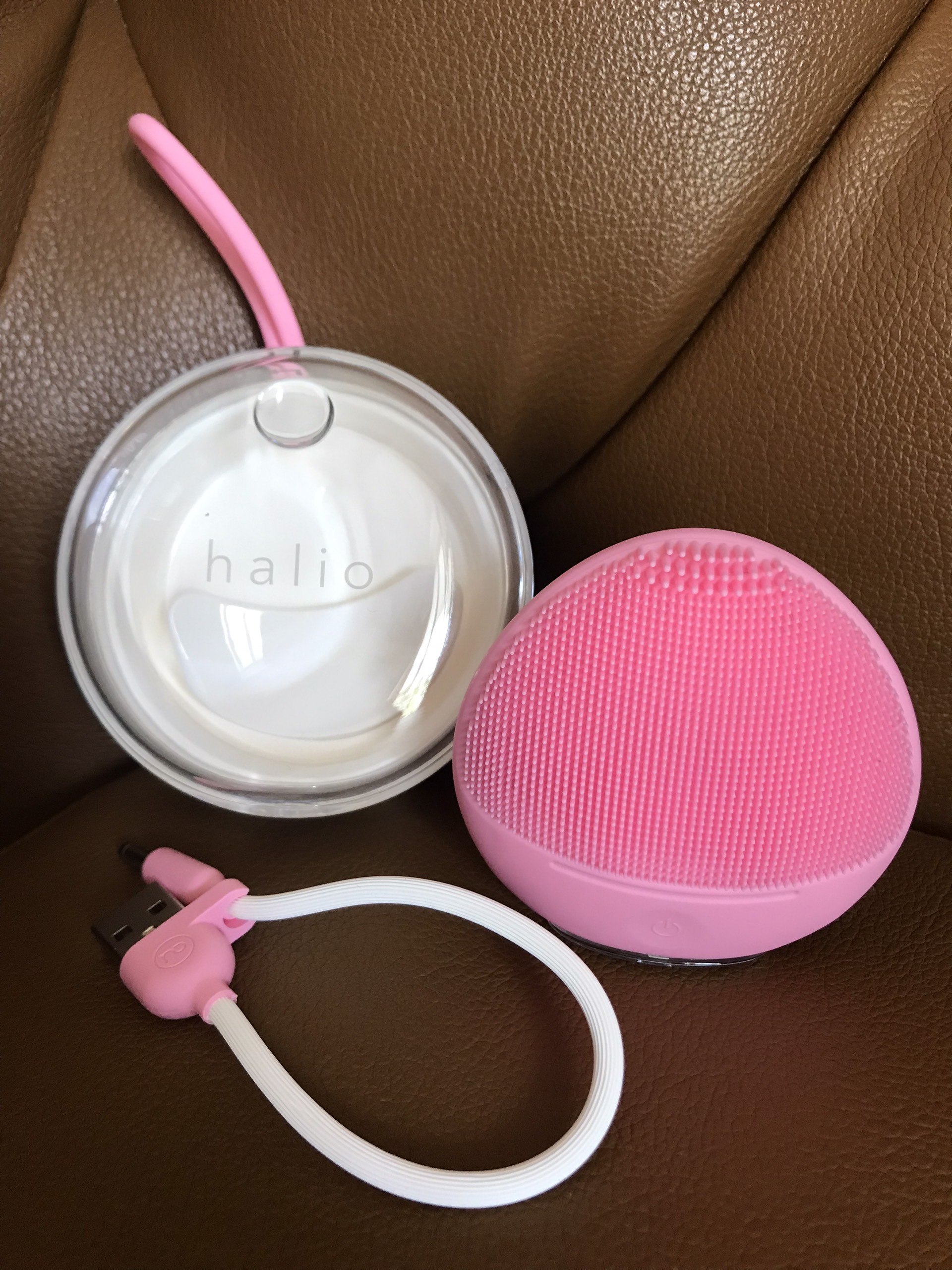 Máy rửa mặt Halio Sensitive màu hồng, bao gồm thiết bị làm sạch và dây sạc USB. Review máy rửa mặt Halio Sensitive cho da nhạy cảm, hỗ trợ làm sạch mụn đầu đen và lỗ chân lông lớn, phù hợp cho người có làn da mỏng manh.