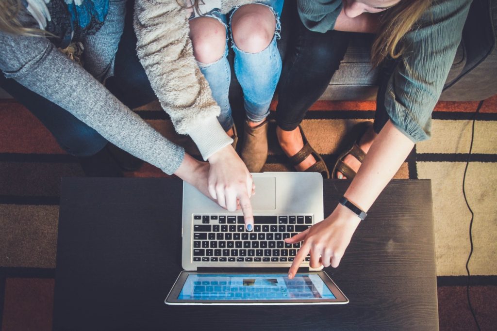 many people pointing at a laptop - B2B personalization