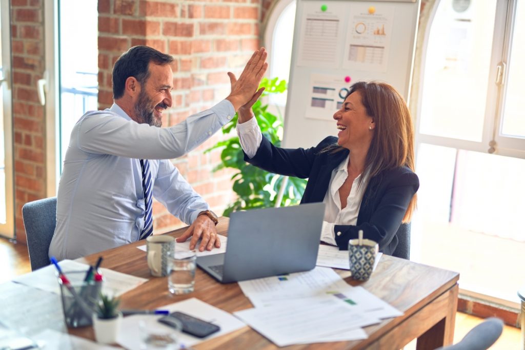 An image of two managers in an office giving each other a high five to illustrate internal stakeholders.