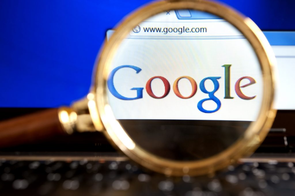 Image showing Google logo and a magnifying glass.