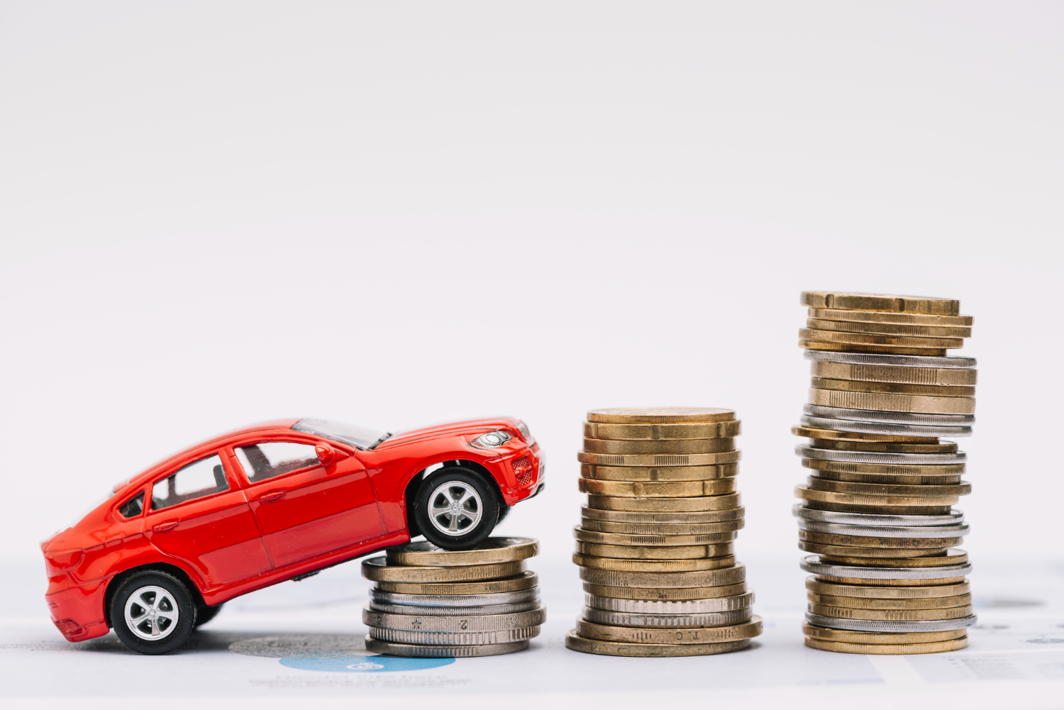 Editors%2 Fimages%2 F1649745942192 Toy Car Going Up Increasing Stack Coins Against White Background
