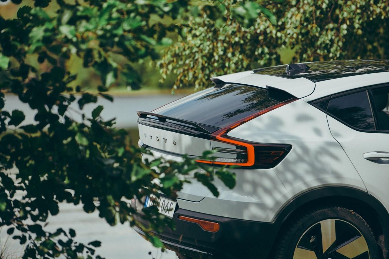 A white car parked next to a body of water Description automatically generated