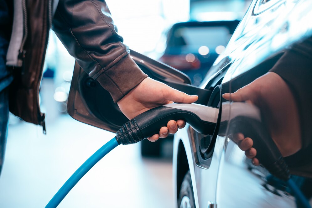 Editors%2 Fimages%2 F1736759570186 Human Hand Is Holding Electric Car Charging Connect Electric Car 1153 5059