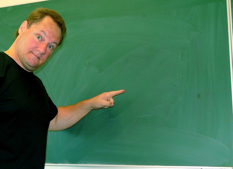 man pointing at a chalkBoard