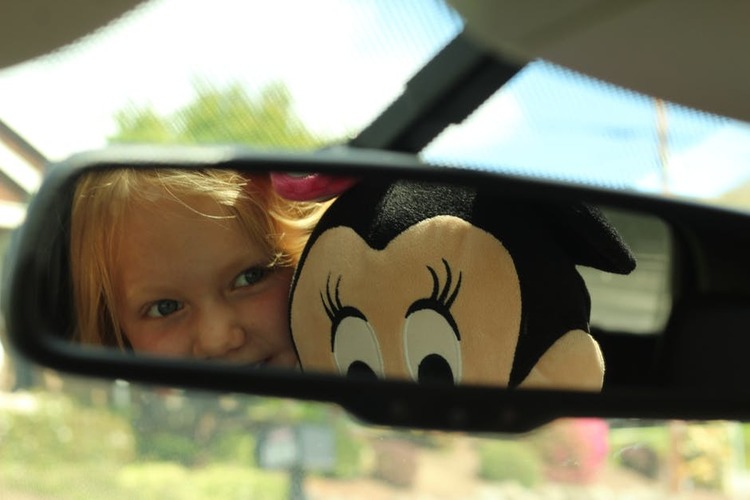 child in rear view mirror car