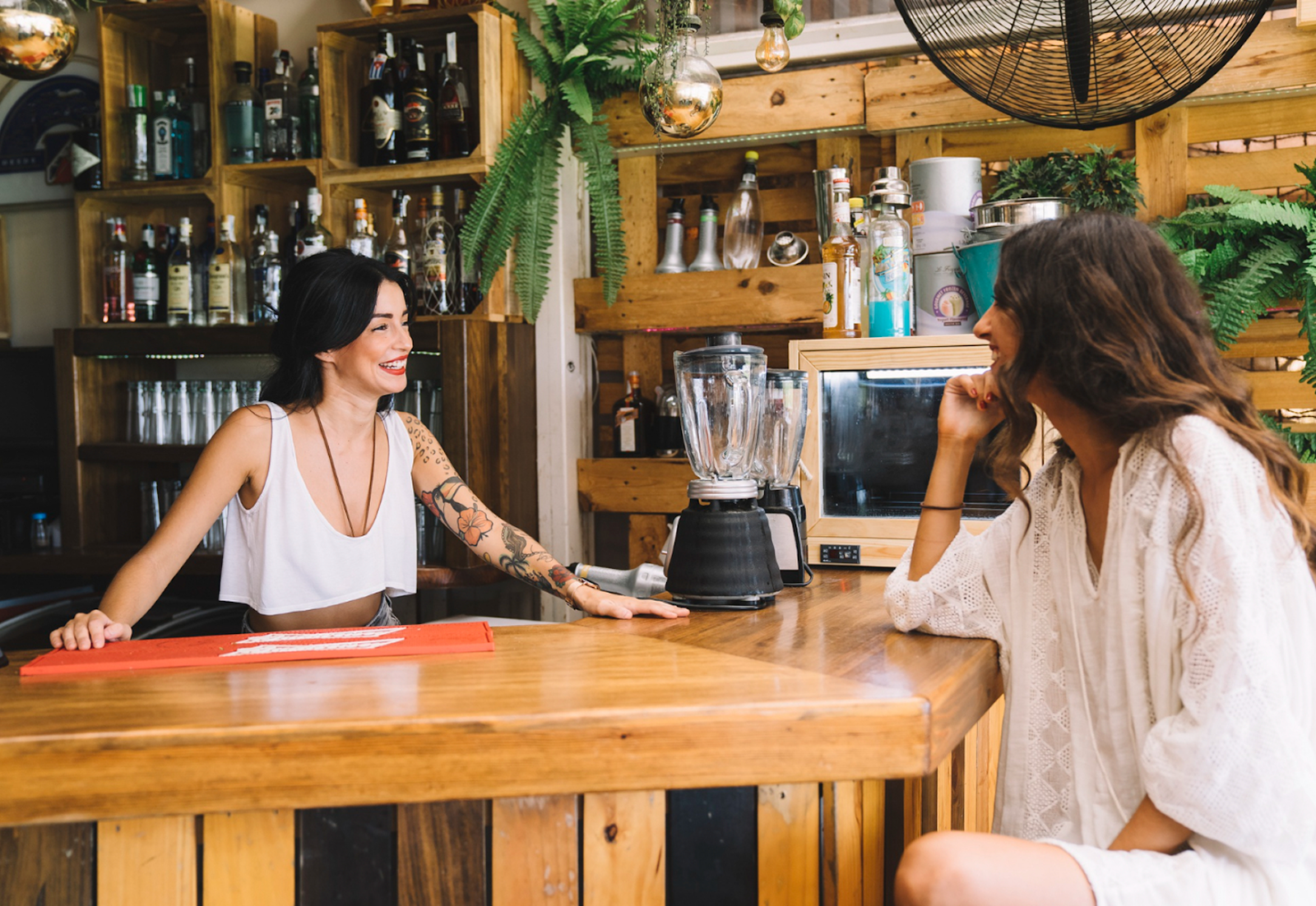 Two women talking at a modern wooden bar