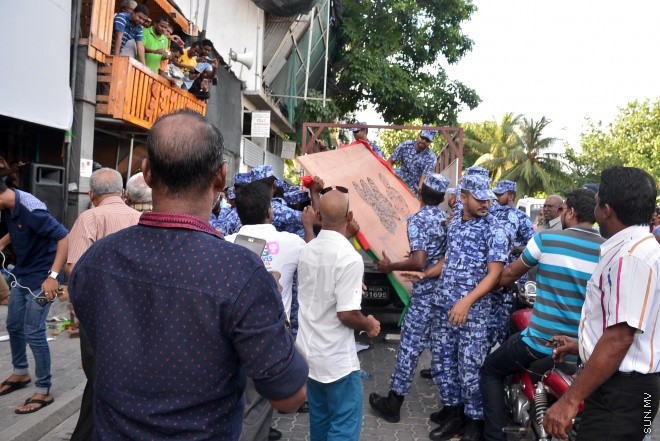 ޖުލައި 29، 2016: އިދިކޮޅު އިއްތިހާދުން އެމްޑީޕީ ހަރުގެ ކުރިމަތީ ބޭއްވި ސައިފޮދަށް ފުލުހުން ހުރަސް އެޅުން: ފުލުހުން ވަނީ އެކަމުގައި ބޭނުން ކުރަމުން ދިޔަ މޭޒުތައް ގެންގޮސްފައި--- ސަން ފޮޓޯ/ މުހައްމަދު އަފްރާހް