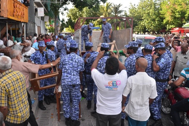 ޖުލައި 29، 2016: އިދިކޮޅު އިއްތިހާދުން އެމްޑީޕީ ހަރުގެ ކުރިމަތީ ބޭއްވި ސައިފޮދަށް ފުލުހުން ހުރަސް އެޅުން: ފުލުހުން ވަނީ އެކަމުގައި ބޭނުން ކުރަމުން ދިޔަ މޭޒުތައް ގެންގޮސްފައި--- ސަން ފޮޓޯ/ މުހައްމަދު އަފްރާހް