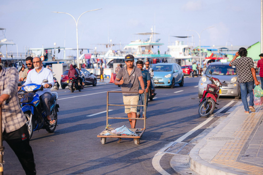 ބާޒާރުމަތީ ސަރަހައްދުގައި މީހަކު އެއްޗެހި އުފުލަނީ -- ސަން ފޮޓޯ/ ހުސައިން އާއިޝް އަޝްރަފް