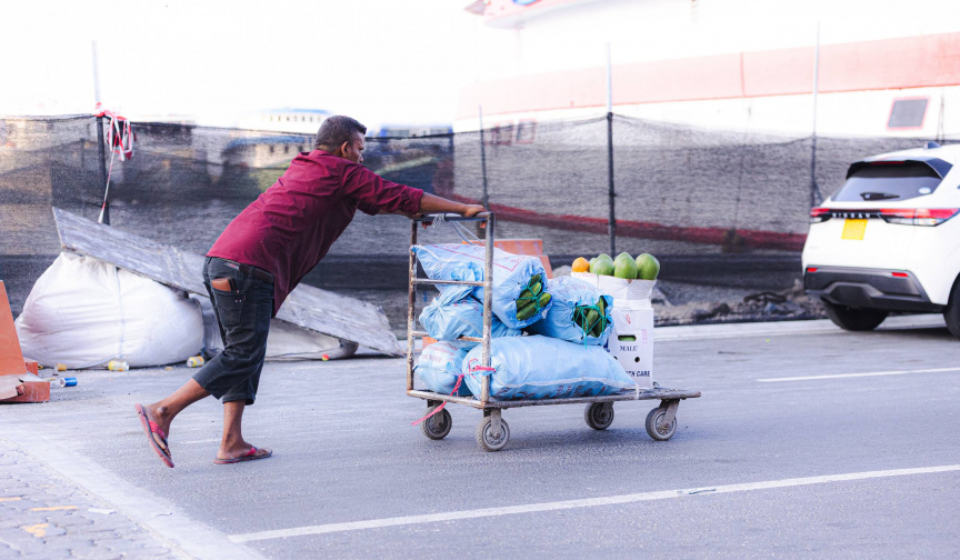 ބާޒާރުމަތީ ސަރަހައްދުގައި މީހަކު އެއްޗެހި އުފުލަނީ -- ސަން ފޮޓޯ/ ހުސައިން އާއިޝް އަޝްރަފް