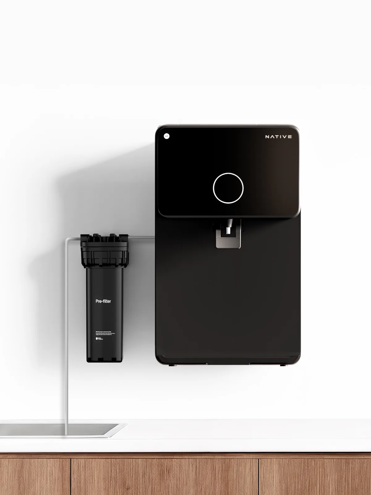 Wall-mounted Native M1 Pro beside a pre-filter joined by a thin inlet pipe.