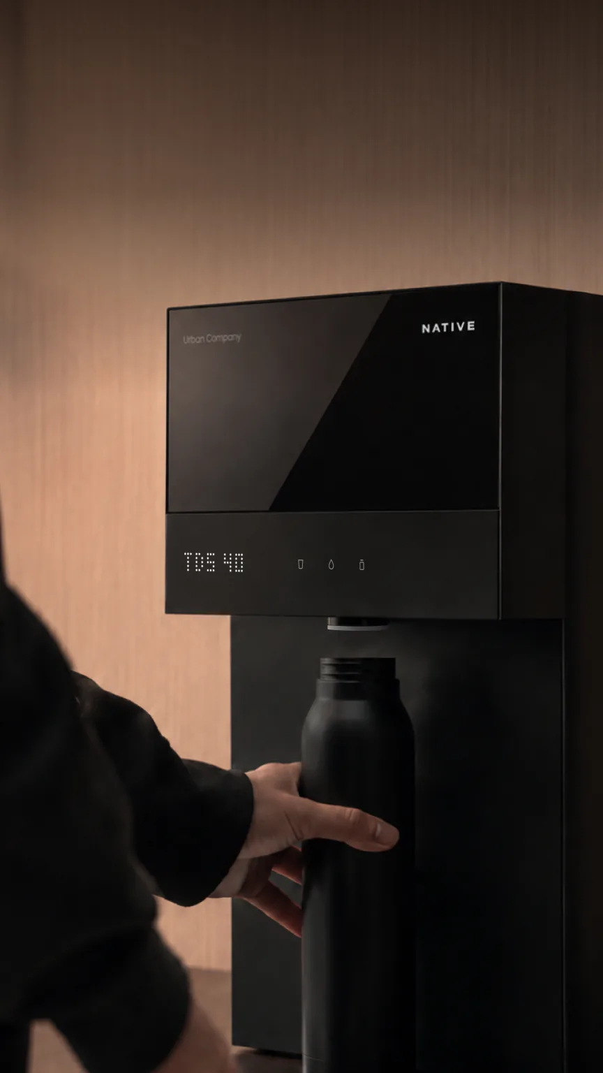 Person filling a bottle at the Native M3 Pro while its display shows TDS 40.