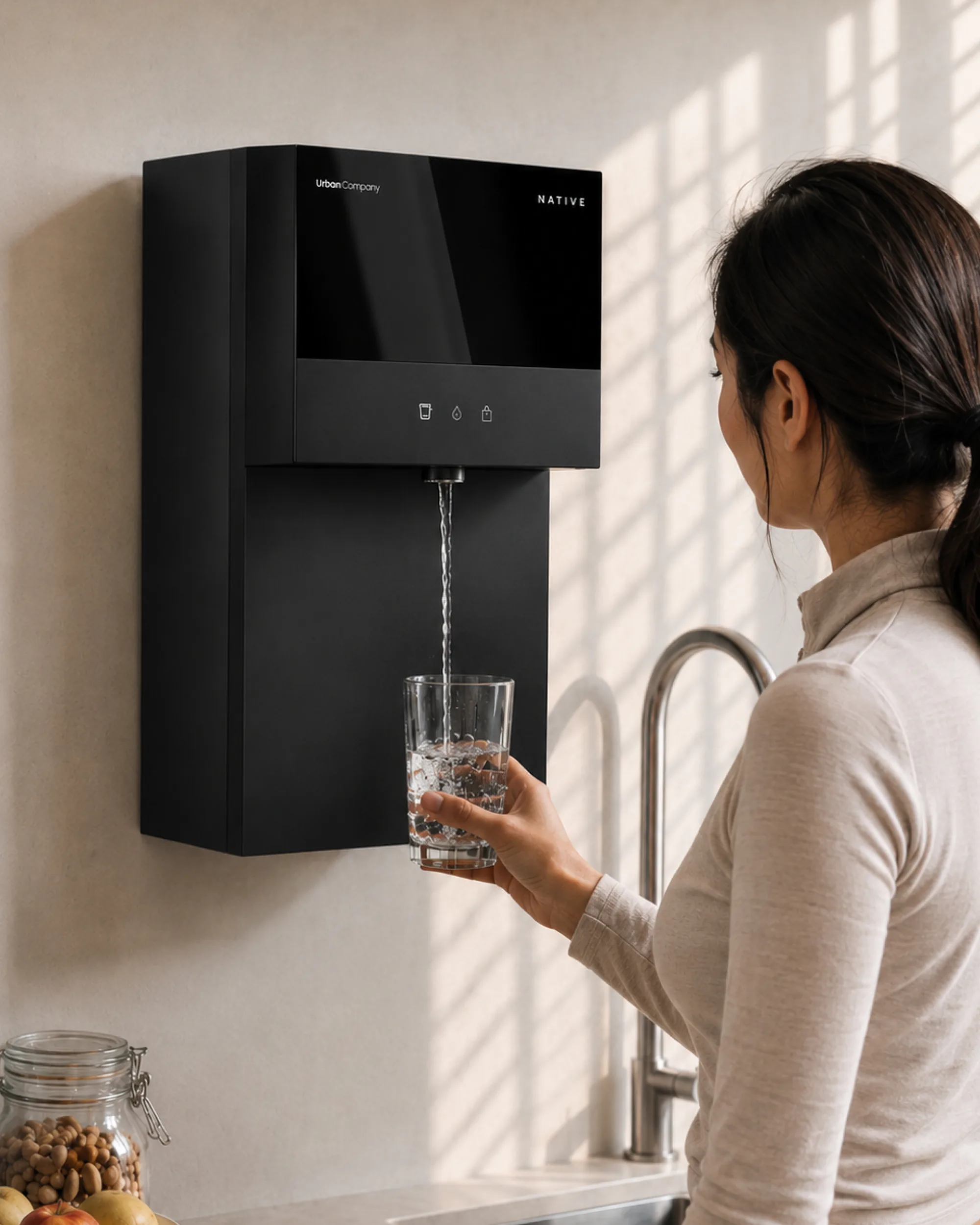 Woman filling a glass from a wall-mounted Native M3 Pro in her kitchen.