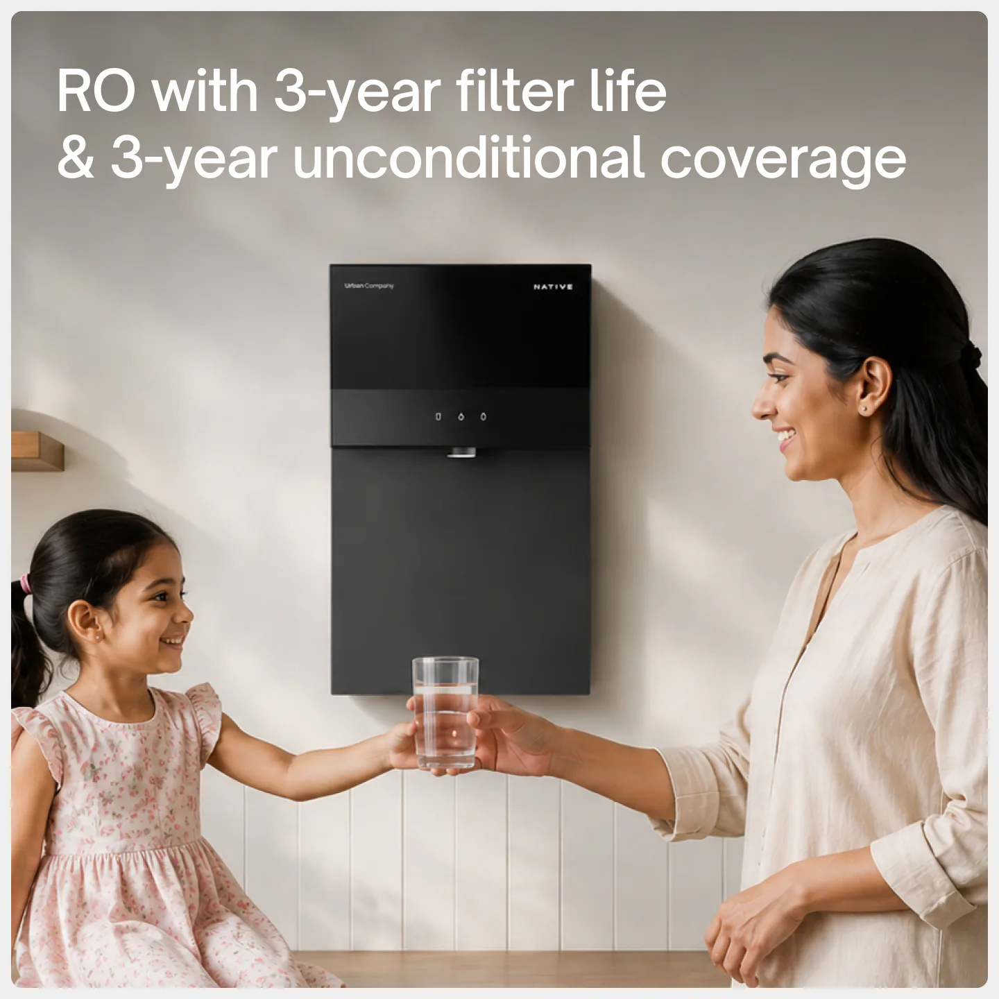 A mother handing her daughter a glass of water from a wall-mounted Native M3: RO with 3-year filter life and 3-year unconditional coverage.